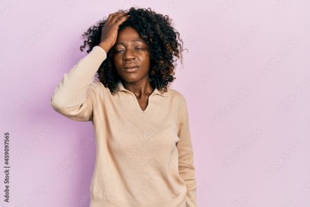 Young african american woman wearing casual clothes confuse and wonder about question. uncertain with doubt, thinking with hand on head. pensive concept.